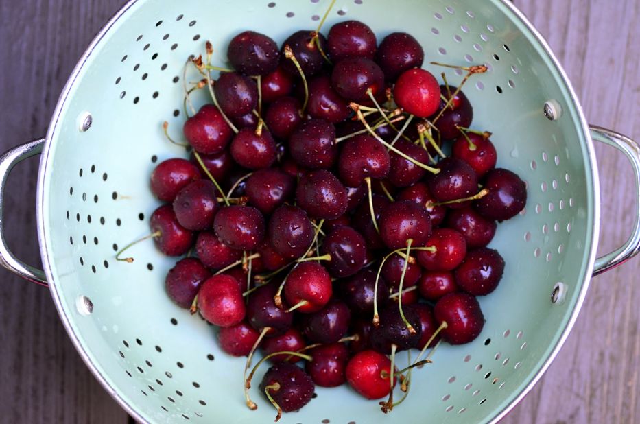 Cherries in mint green colander